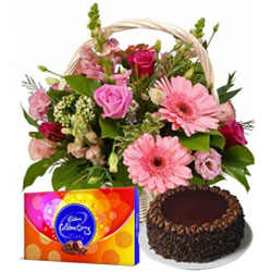 Enticing Chocolate Cake with Seasonal Flowers Basket and Cadbury Celebrations